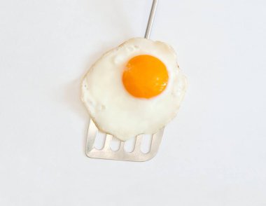 Sahanda yumurta üzerinde gümüş bir spatula