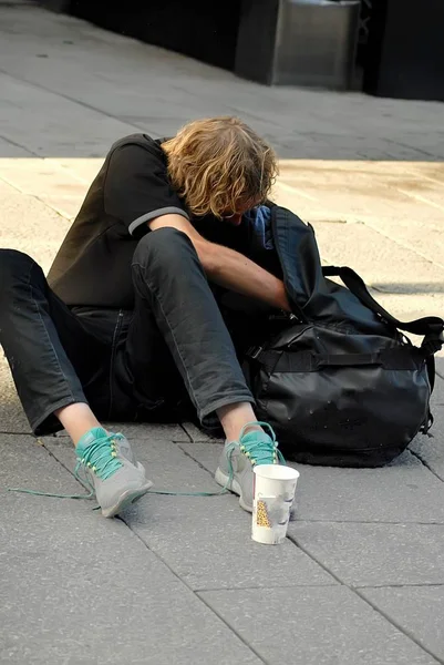 Homeless man sitting on a street — Stock Photo, Image