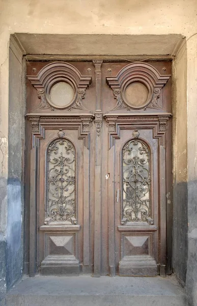 Weathered wooden door with forged grill