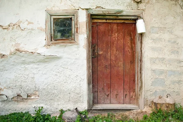 Деревянная дверь из деревенского сарая с канистрой белого молока — стоковое фото