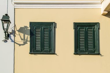 Sarı cephe üzerinde yeşil ahşap pencere