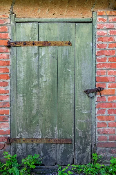 旧木门在乡村砖房漆成绿色 — 图库照片