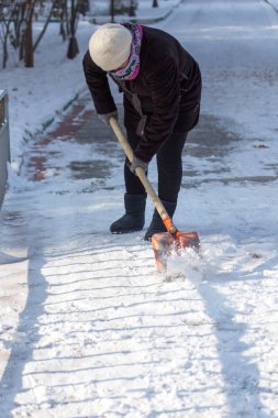 çalışan kadın kar küreği doğada temizler