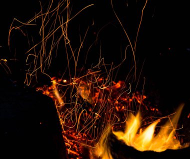 Siyah arkaplanda kıvılcımlar saçan ateş