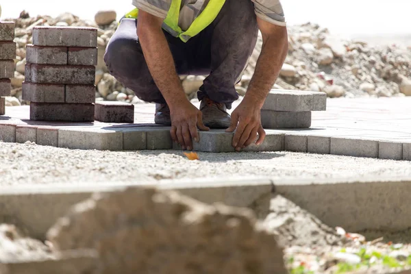 İşçi yola kaldırım taşı koyar