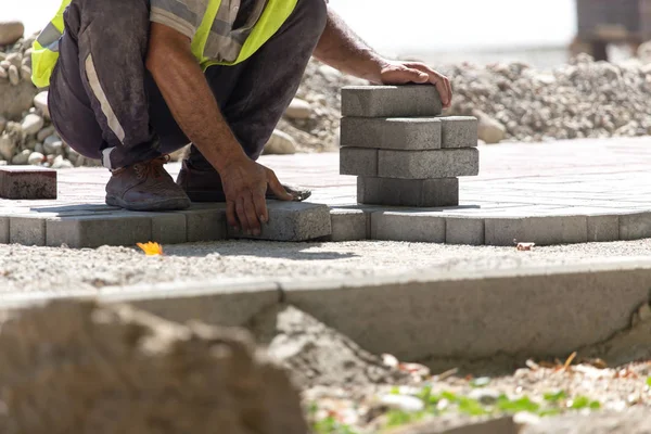 İşçi yola kaldırım taşı koyar