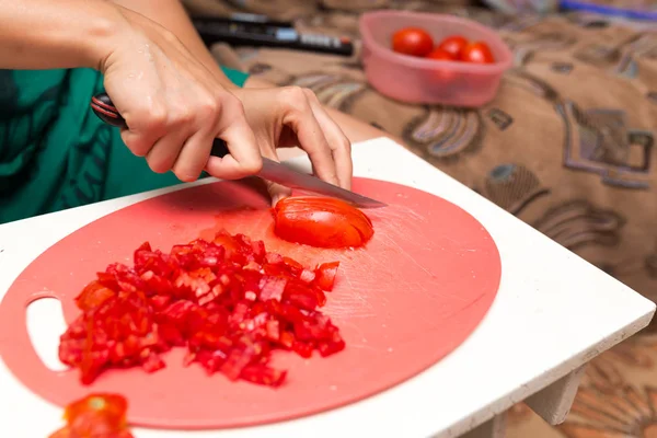 Fille coupe un couteau de tomate — Photo