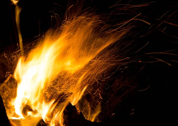 Eld med gnistor på en svart bakgrund — Stockfoto