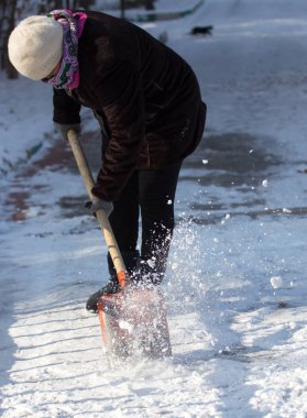 çalışan kadın kar küreği doğada temizler
