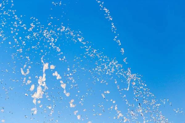 青い空を背景に噴水から水が飛び散る — ストック写真