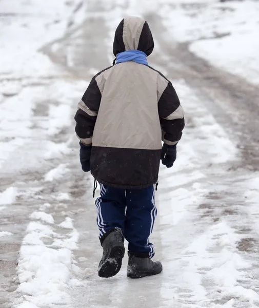 Boy walking along the road in the winter — Stock Photo, Image