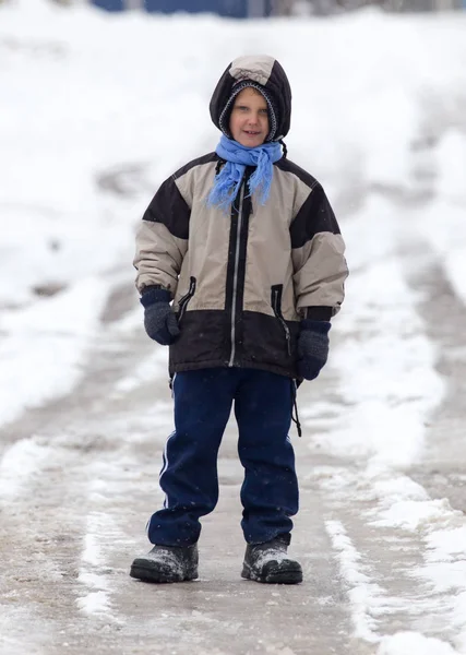 Garçon marchant le long de la route en hiver — Photo