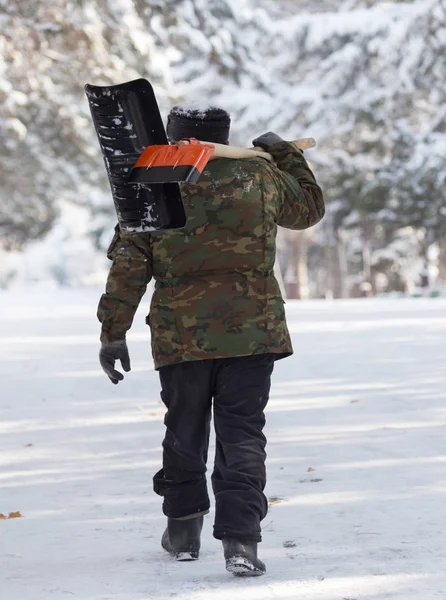 Trabajador limpia la pala de nieve en la naturaleza —  Fotos de Stock