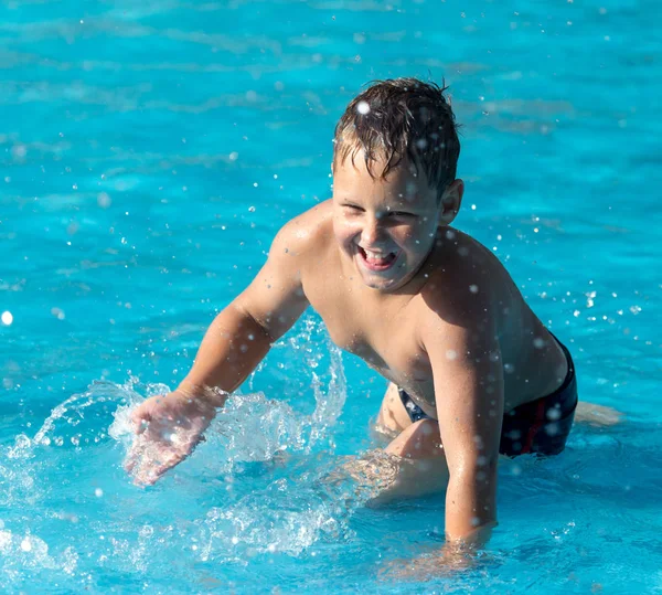 Çocuk su parkında su sıçratarak yüzüyor. — Stok fotoğraf