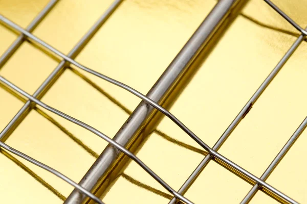 Металева сітка на золотому фоні — стокове фото