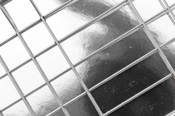 Metal mesh on a silver background — Stock Photo, Image
