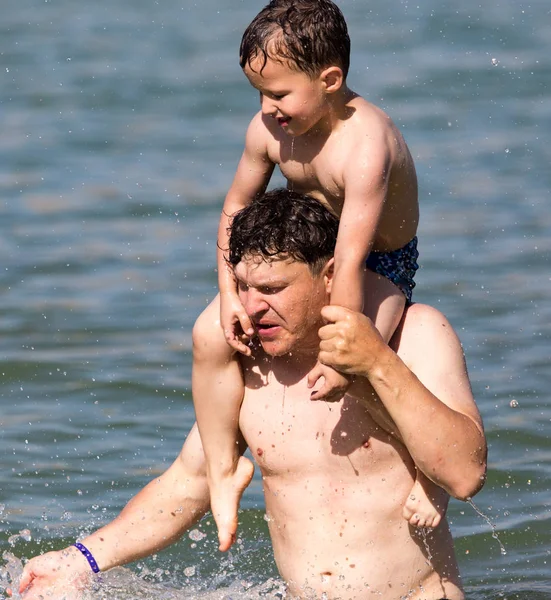 Vader en zoon zwemmen in het meer — Stockfoto