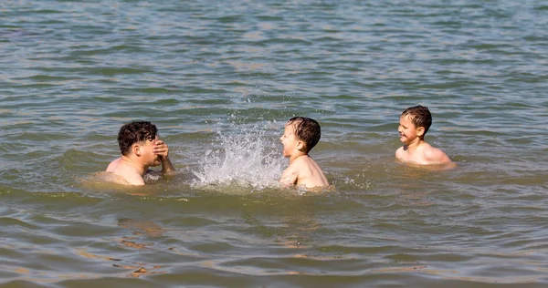 Vader met twee kinderen zwemmen in het meer — Stockfoto