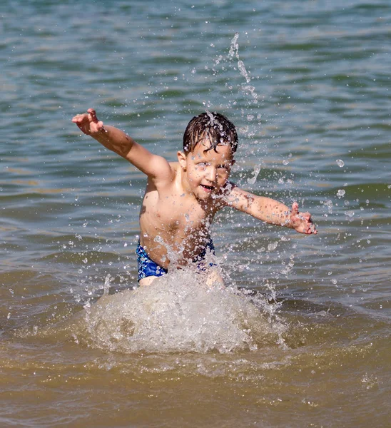Мальчик купается в озере на пляже — стоковое фото
