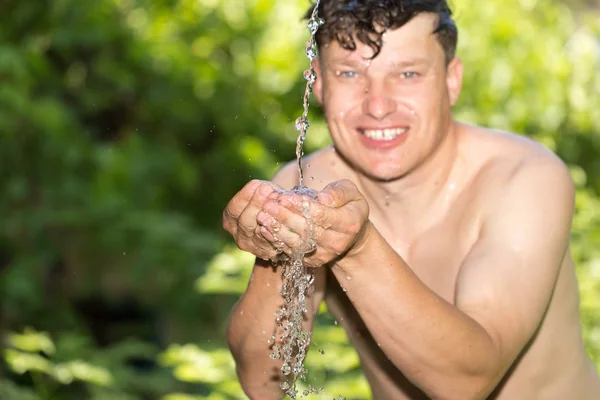 Человек в распылителе воды — стоковое фото