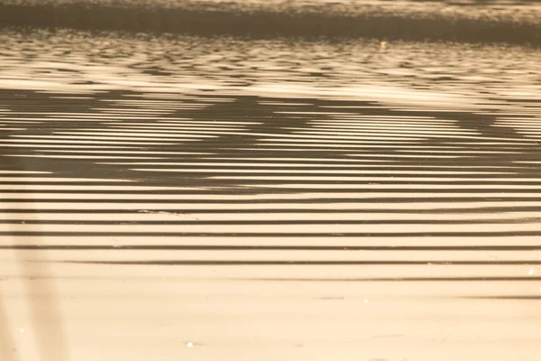 Uitgestrektheid van water op de zonsondergang achtergrond — Stockfoto