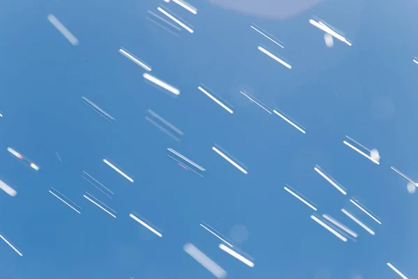 Chuva cai em um fundo do céu azul — Fotografia de Stock