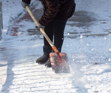 çalışan kadın kar küreği doğada temizler