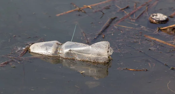 Butelka w jeziorze jako śmieci — Zdjęcie stockowe