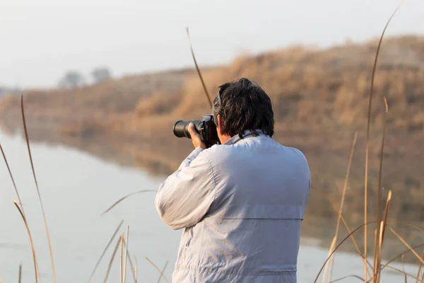 Uomo fotografa il lago — Foto Stock