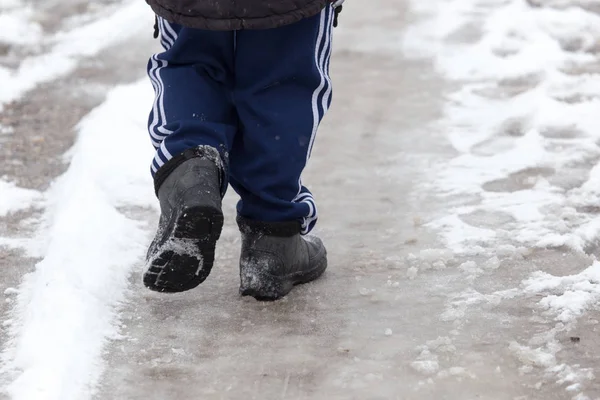 Garçon marchant le long de la route en hiver — Photo