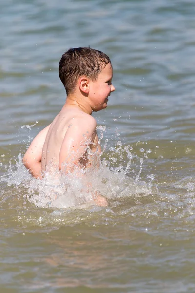 少年は湖で海に浸かっています — ストック写真