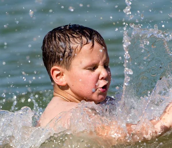 Το αγόρι λούζεται στη λίμνη στην παραλία. — Φωτογραφία Αρχείου