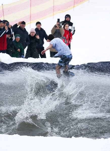 Lipetsk, Rusland -, 31 maart 2018: Een man snowboarden van Berg tot water — Stockfoto