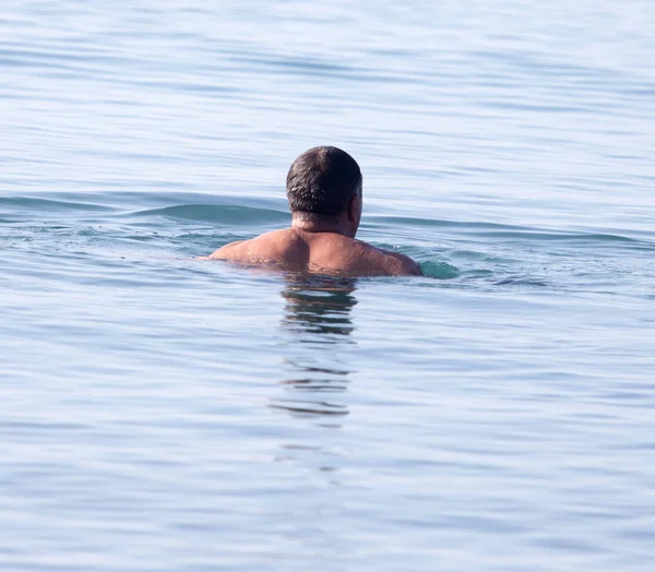 Uomo bagna nel lago sulla spiaggia — Foto Stock