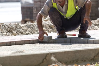 İşçi yola kaldırım taşı koyar