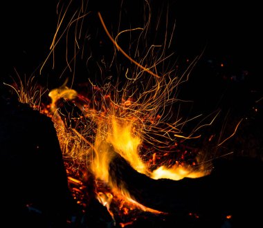 Siyah arkaplanda kıvılcımlar saçan ateş