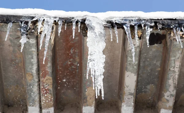 Los carámbanos sobre el techo de la casa en invierno —  Fotos de Stock