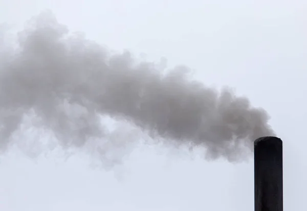 Smoke from a pipe on a cloudy sky — Stock Photo, Image