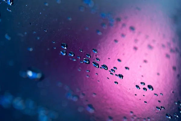 Gocce d'acqua su fondo rosa — Foto Stock