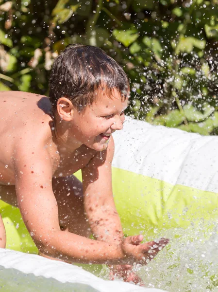 Boy pours water from the pool in nature — Stock Photo, Image