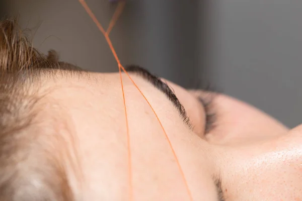 Grooming de wenkbrauwen draad in een schoonheidssalon. sluiten — Stockfoto