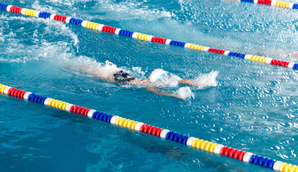 Девочка плавает в бассейне