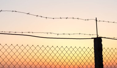 Gün batımında dikenli tel