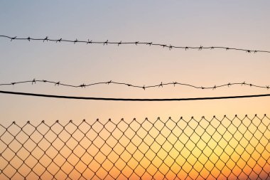 Gün batımında dikenli tel