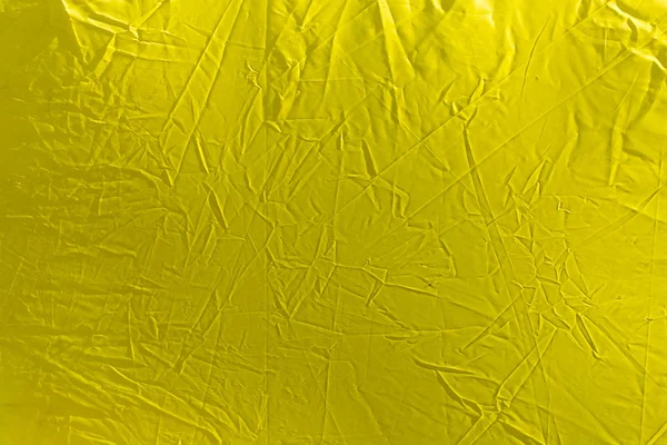 Pano amarelo enrugado como fundo — Fotografia de Stock