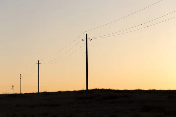 Gün batımında elektrik direkleri — Stok fotoğraf