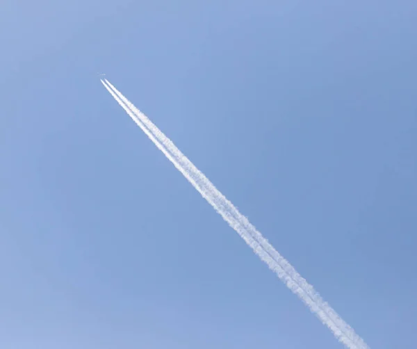 Traço de um avião contra o céu azul — Fotografia de Stock