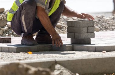 İşçi yola kaldırım taşı koyar