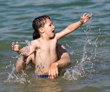 Oğlan gölde sahile doğru yıkandı.