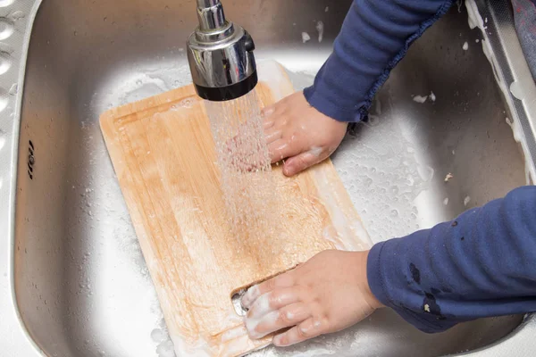 Niño lavando platos en la cocina —  Fotos de Stock